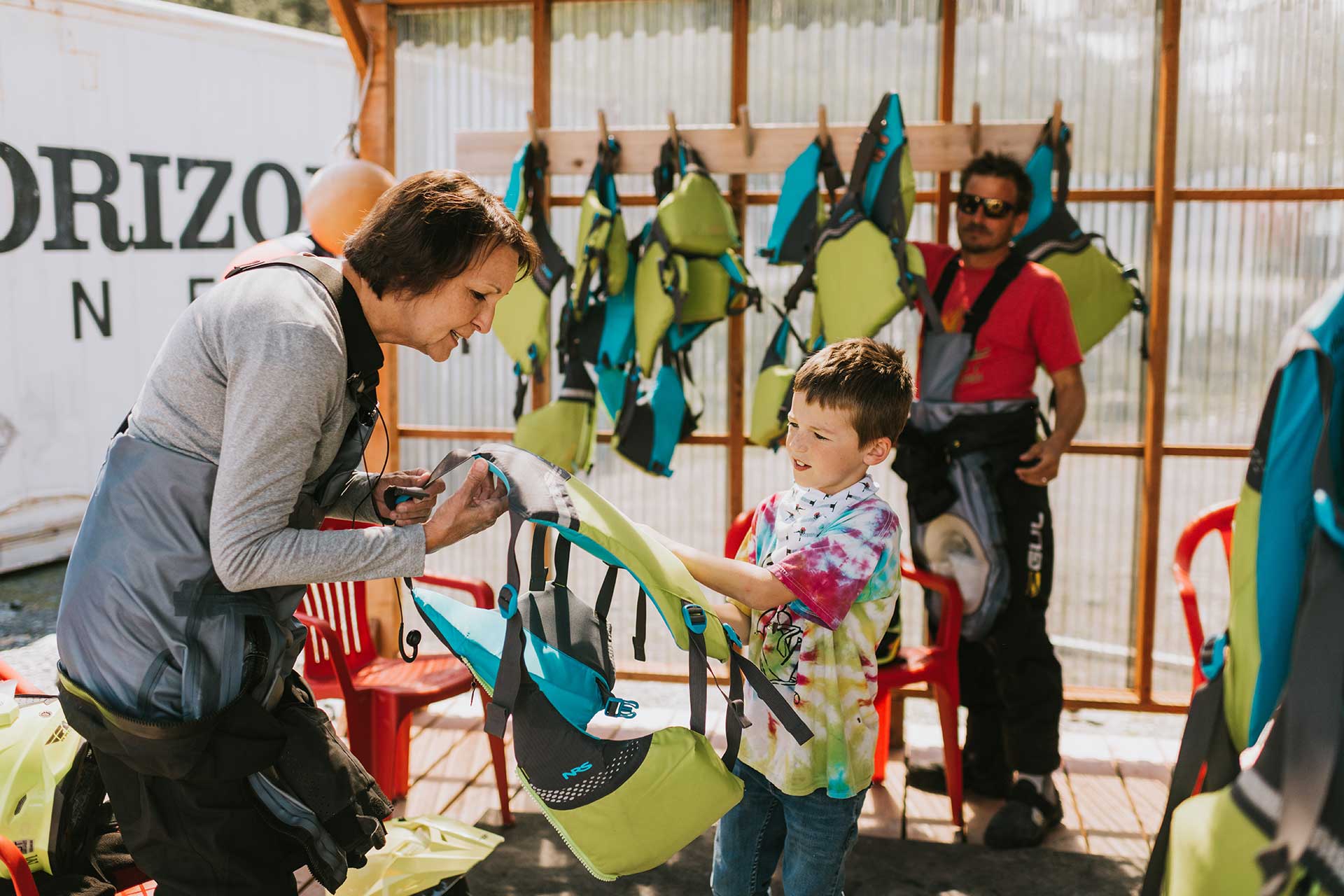 Young Boy Helping Elder Woman with Jetski Vest