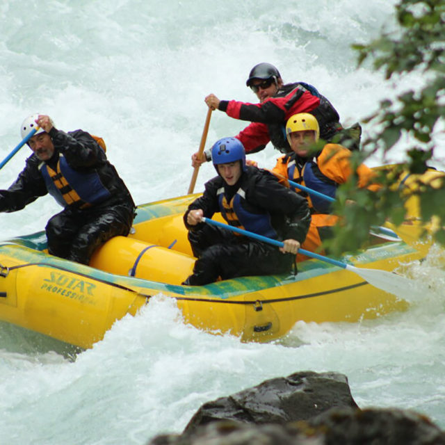 Rafters Riding White Water Rapids in Yellow Raft