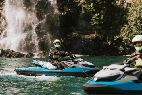 Jetski Riders in Front of Waterfall