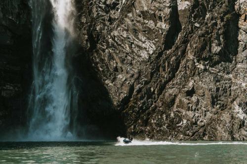 Jetski Rider Riding Past Waterfall
