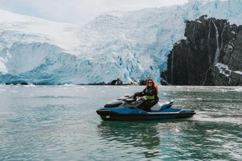 Smiling Woman on Jetski in front of Large Alaskan Glacier